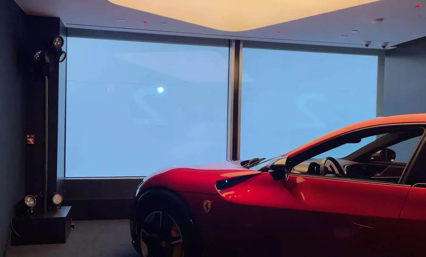 The Purosangue projected at full size onto a switchable glass panel at Ferrari’s New York dealership