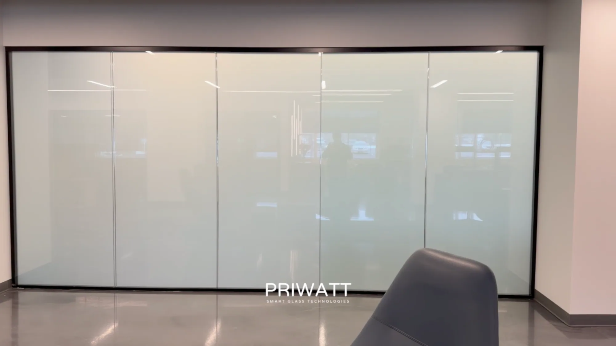 The same office wall switched to privacy, the glass an even white