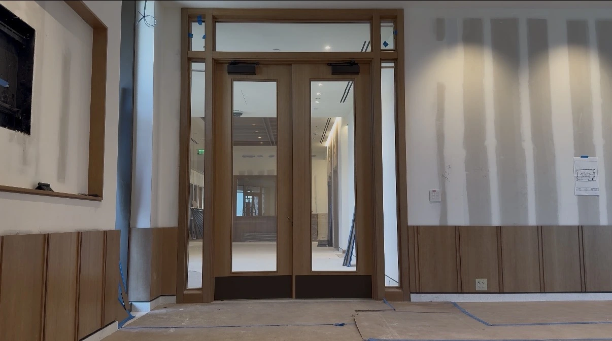 Entrance doors at the Jim Moran Foundation, the reverse glass clear and the room beyond visible through it
