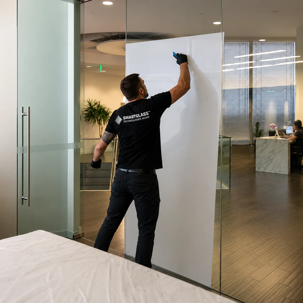 PriWatt technician applying smart film to an office glass partition