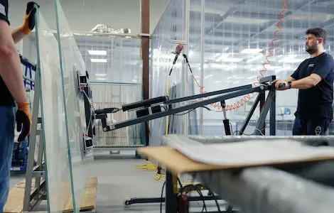 A large laminated panel lifted onto the line