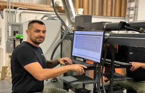 A PriWatt engineer at the controls of the lamination line