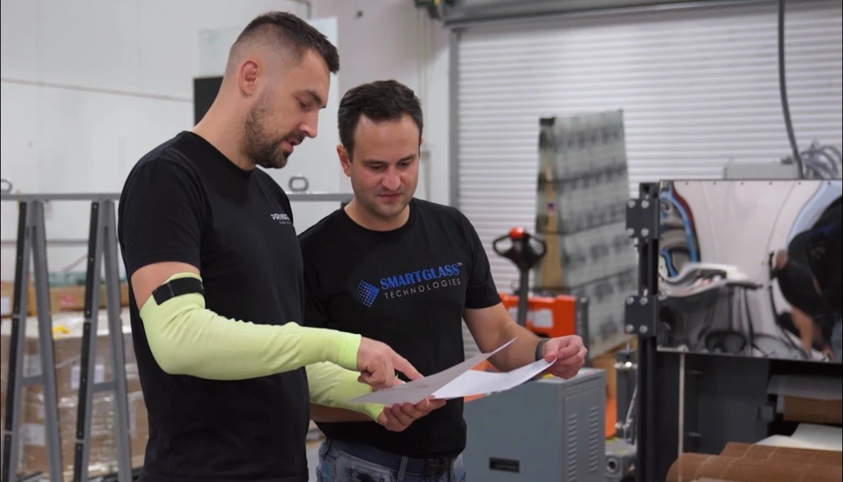 A PriWatt and a Smart Glass Technologies engineer reading a shop drawing together on the shop floor