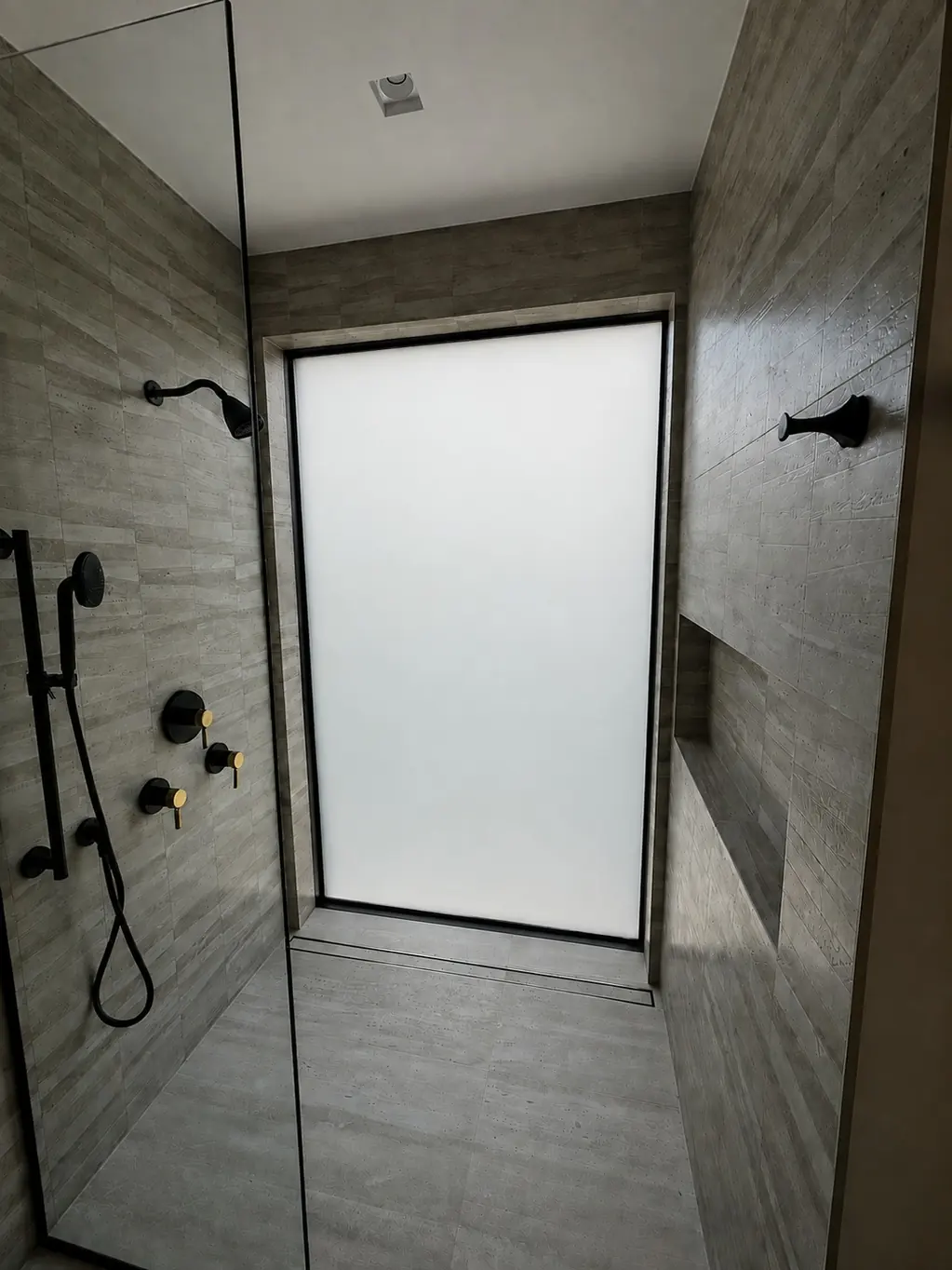 The same shower window switched to privacy, the glass an even white and the garden no longer visible